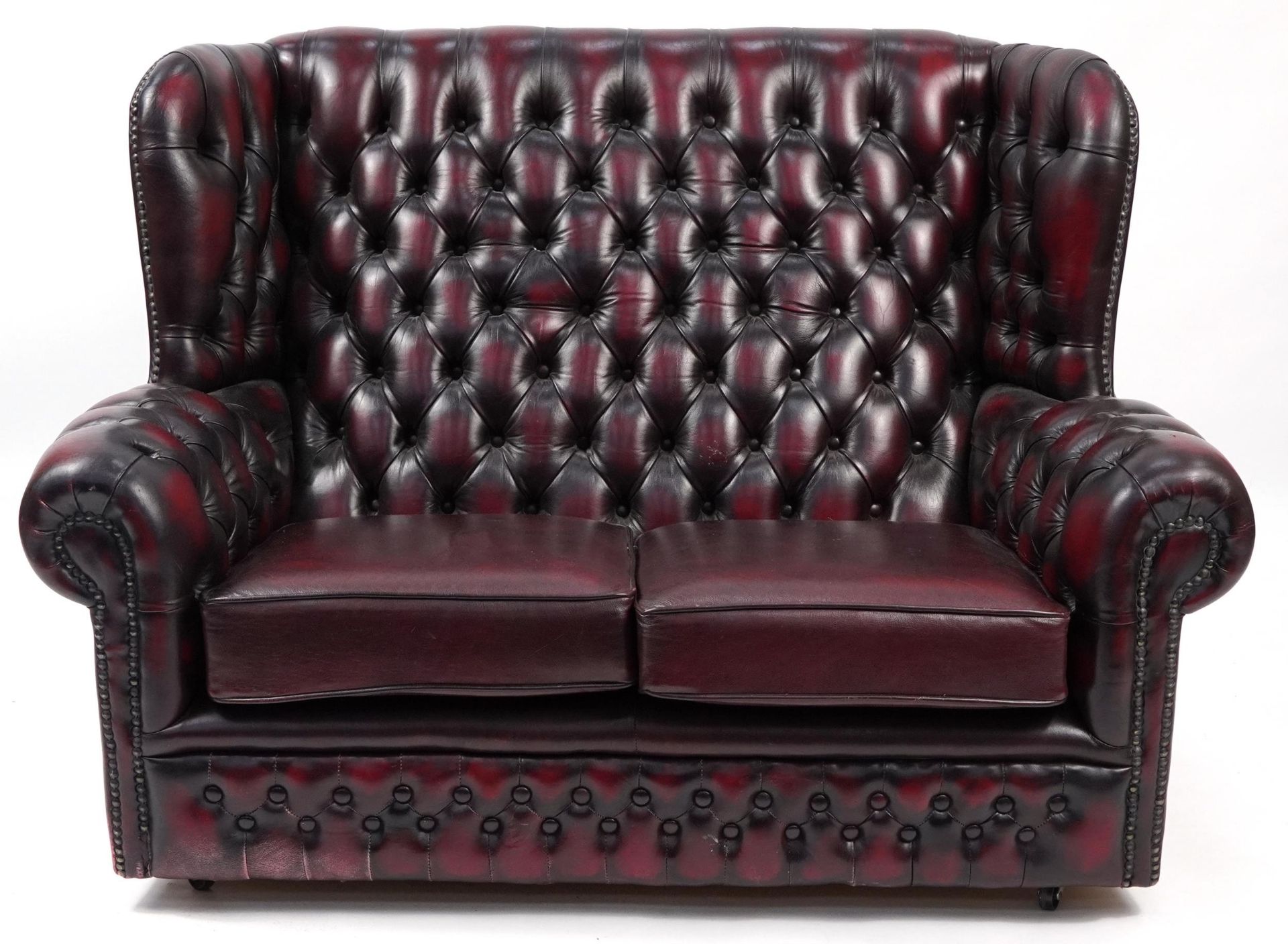 Oxblood leather button back two seater wingback settee, 130cm wide