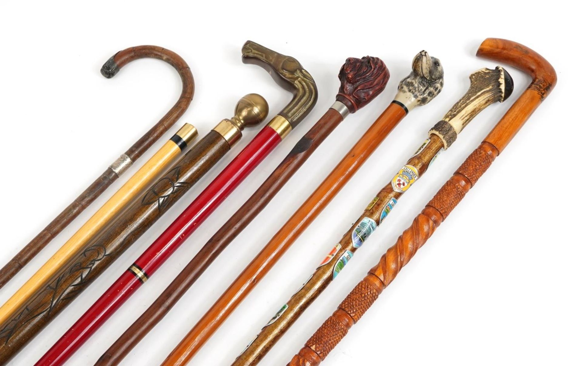 Seven walking sticks including a pool cue stick, one with horn handle and one bamboo with silver