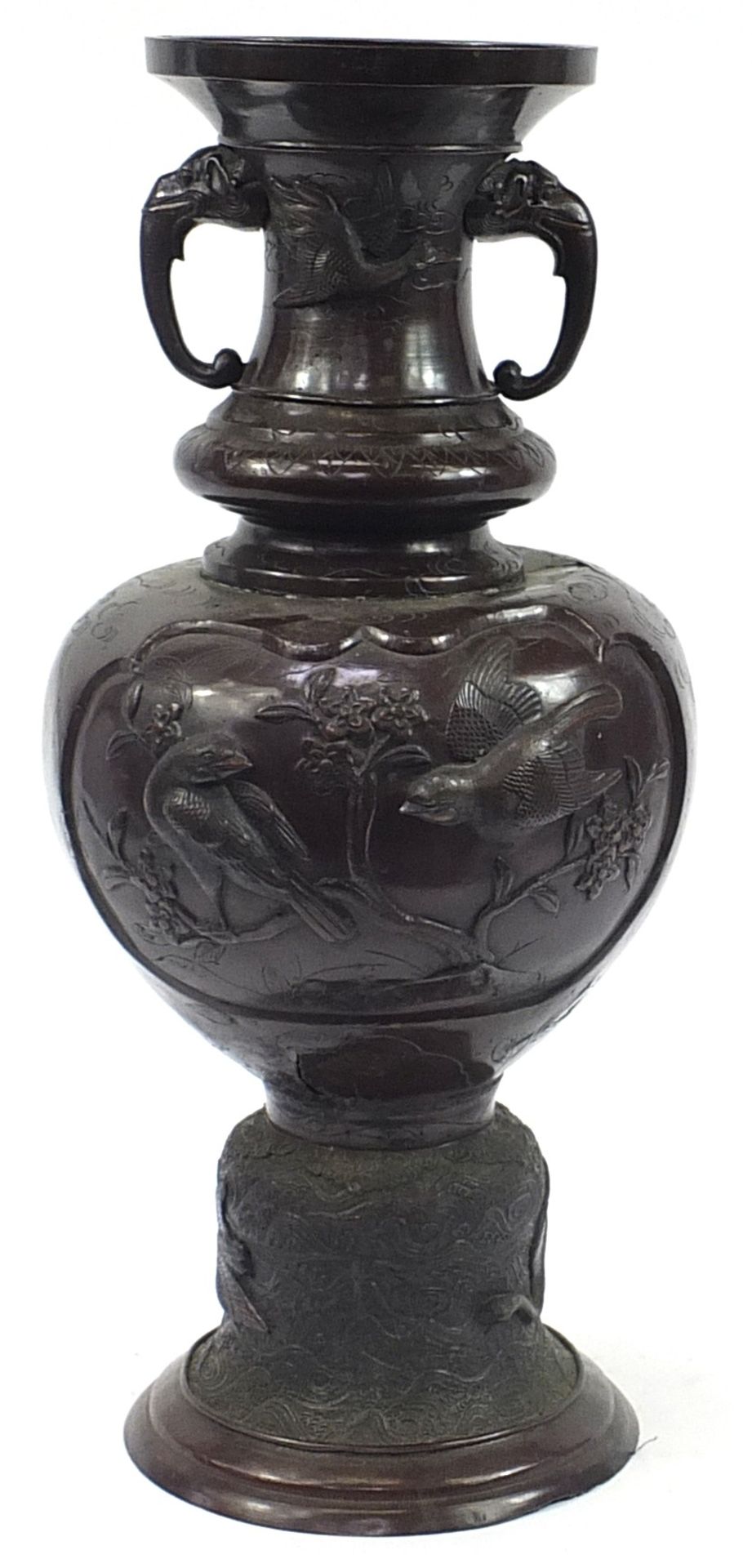 Large Japanese floor standing patinated bronze vase with twin handles decorated in relief with