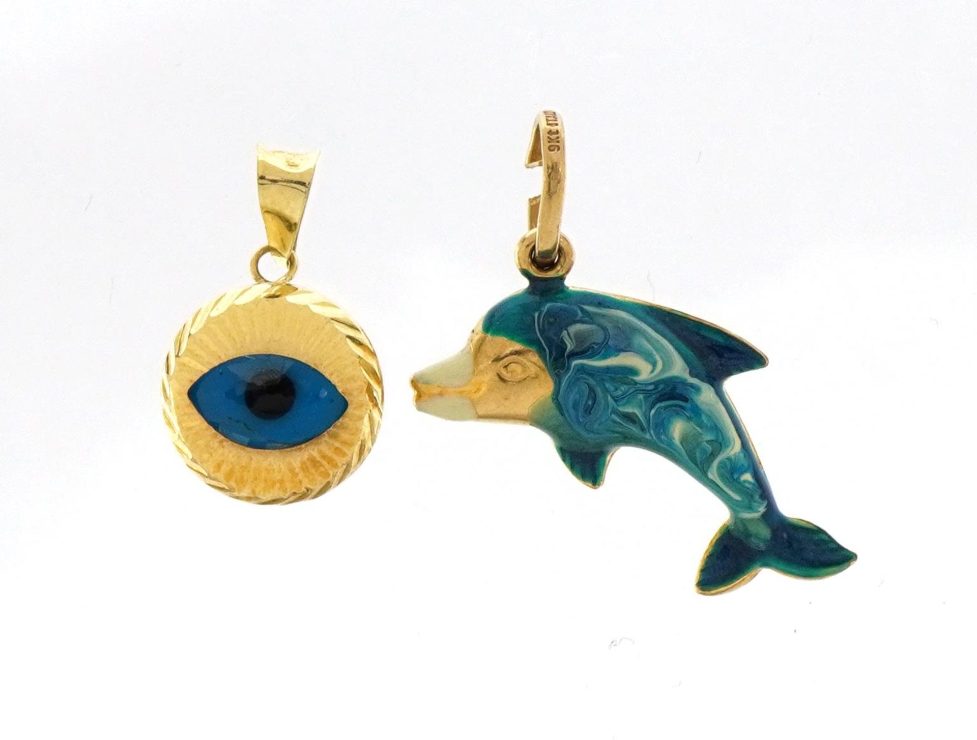 14ct gold all seeing eye pendant and a 9ct gold and enamel dolphin charm, the largest 2.4cm wide,