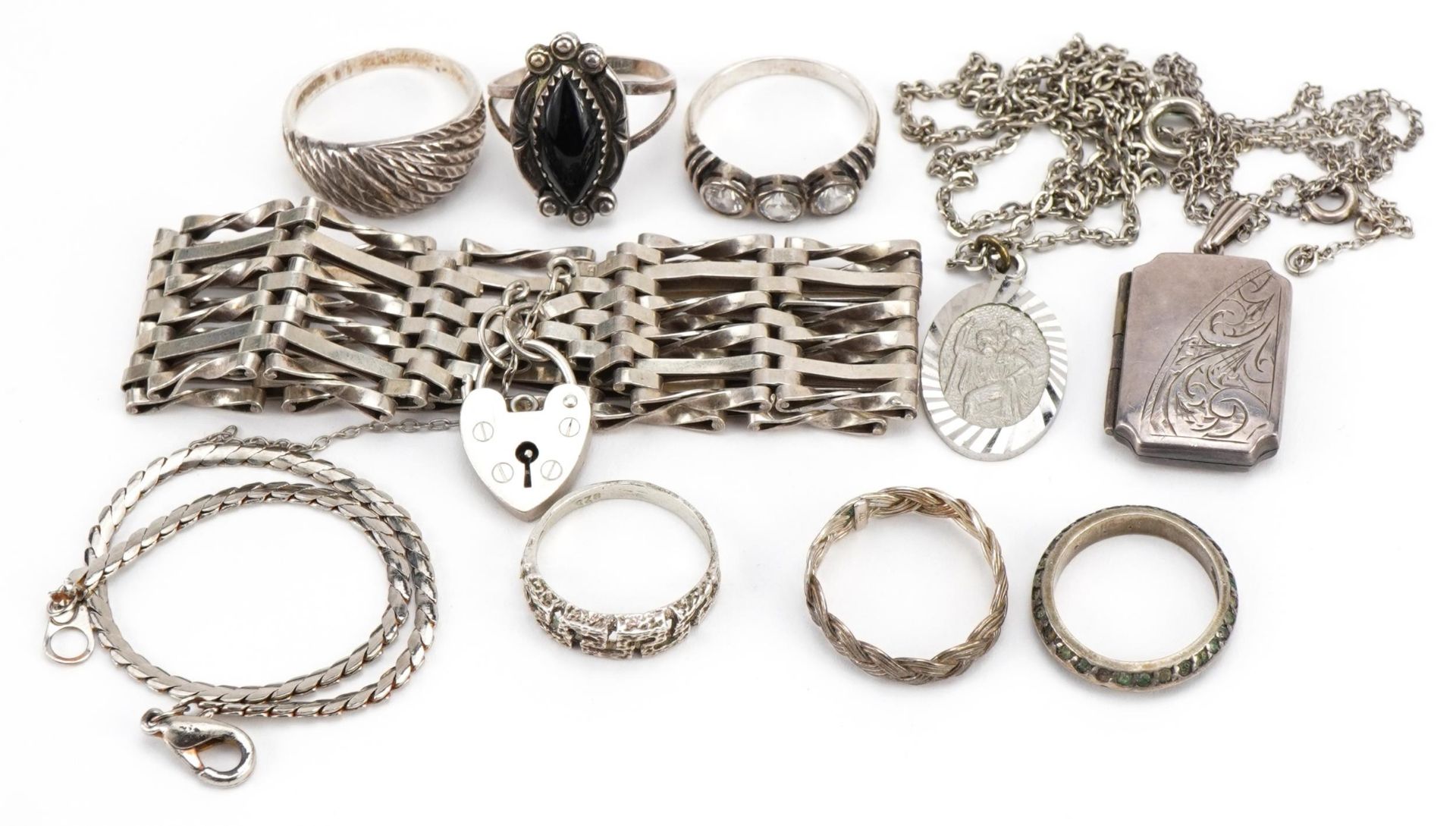 Silver and white metal jewellery including rings, gate link bracelet and rectangular locket with