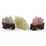 Two Chinese carved jade and rose quartz rabbits with hardwood stands and a carved jade fish, the