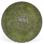 Scandinavian cast metal plate decorated in relief with two leaping deer, 26.5cm in diameter