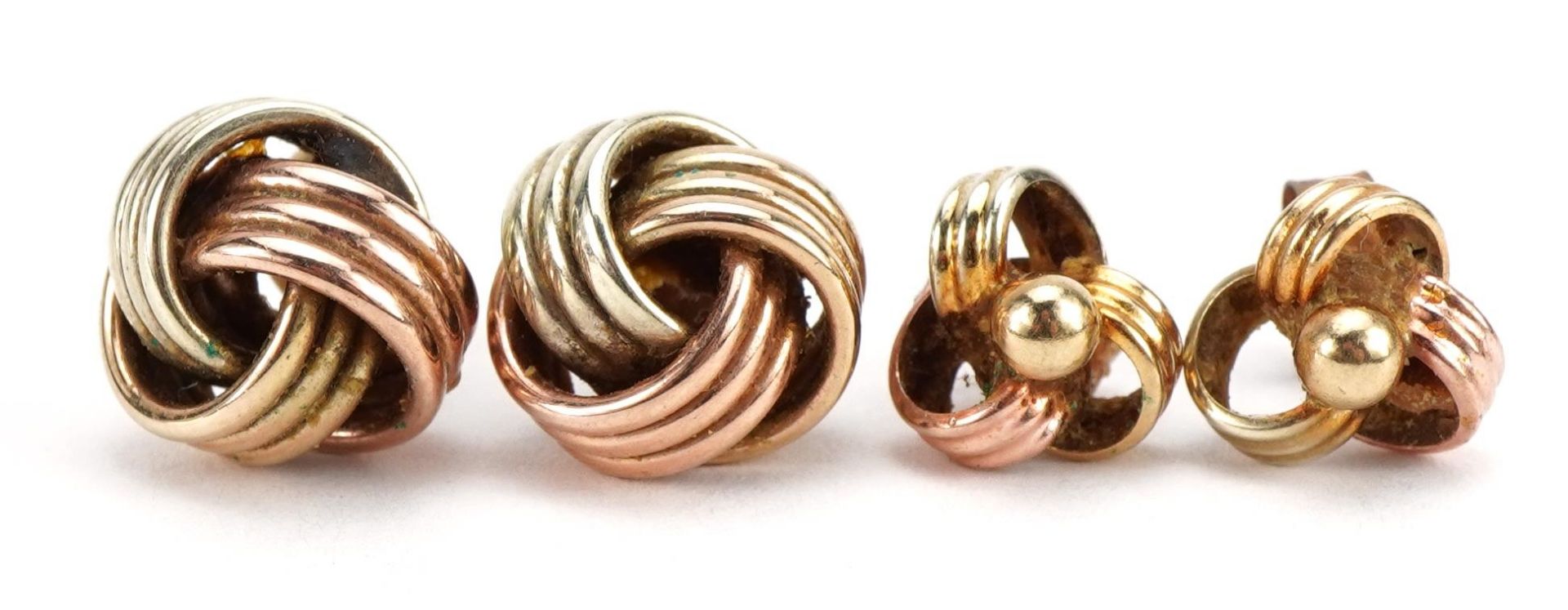 Two pairs of two tone gold knot design earrings, one marked 375, the largest 1.1cm high, total 3.5g