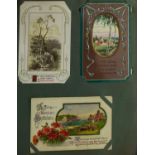 Early 20th century and later topographical and social history postcards arranged in an album, some