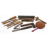 Selection of antique woodworking tools including chisels, wooden and brass Rabone level, leather