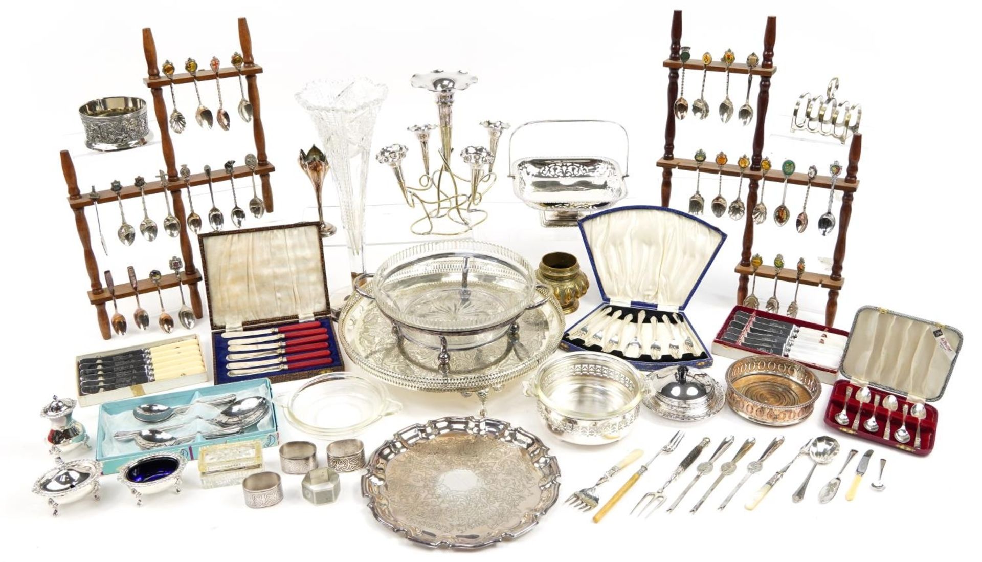 Silver plate including circular four footed salver, souvenir teaspoons on display stands, cruets,