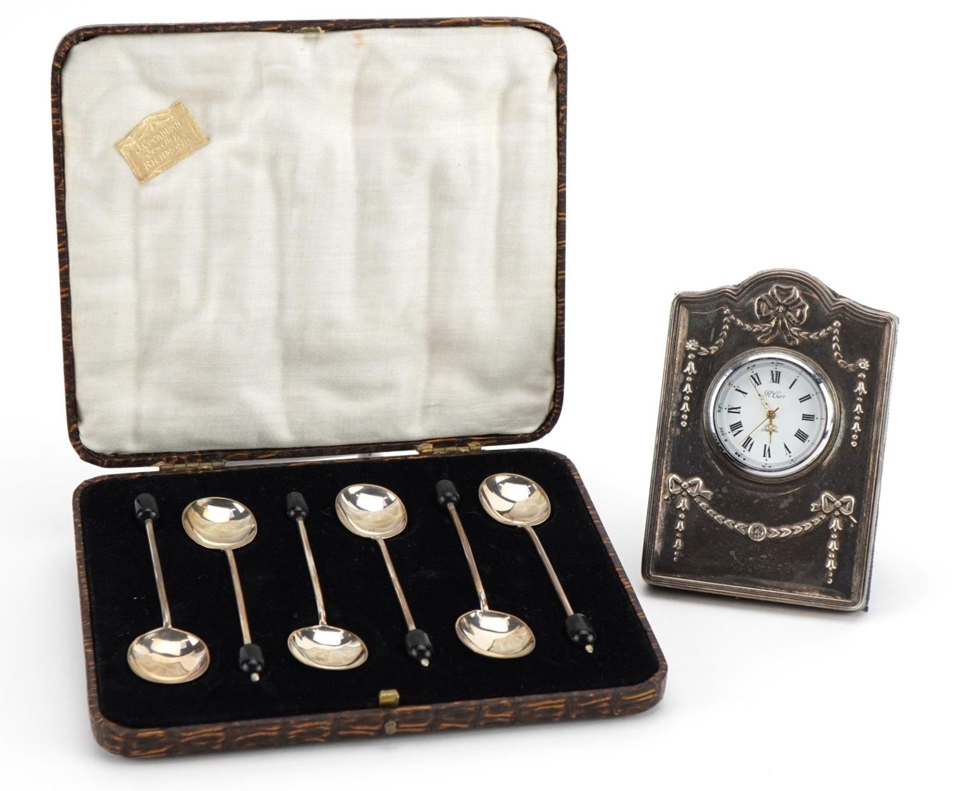 Carr's miniature silver easel clock and set of six silver coffee bean spoons with fitted case, the