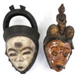Two African tribal interest partially painted face masks, the largest 36cm high