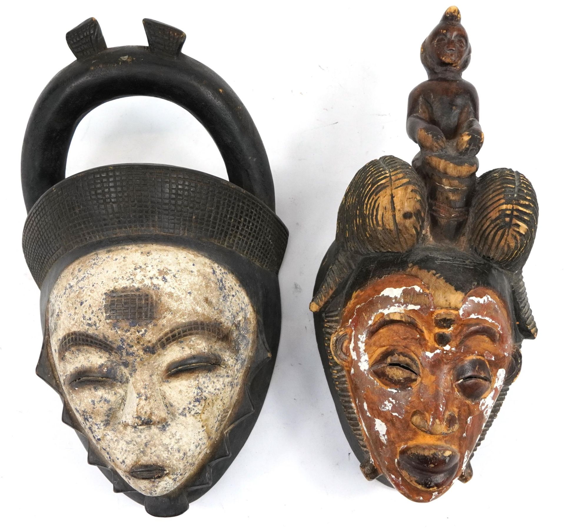 Two African tribal interest partially painted face masks, the largest 36cm high