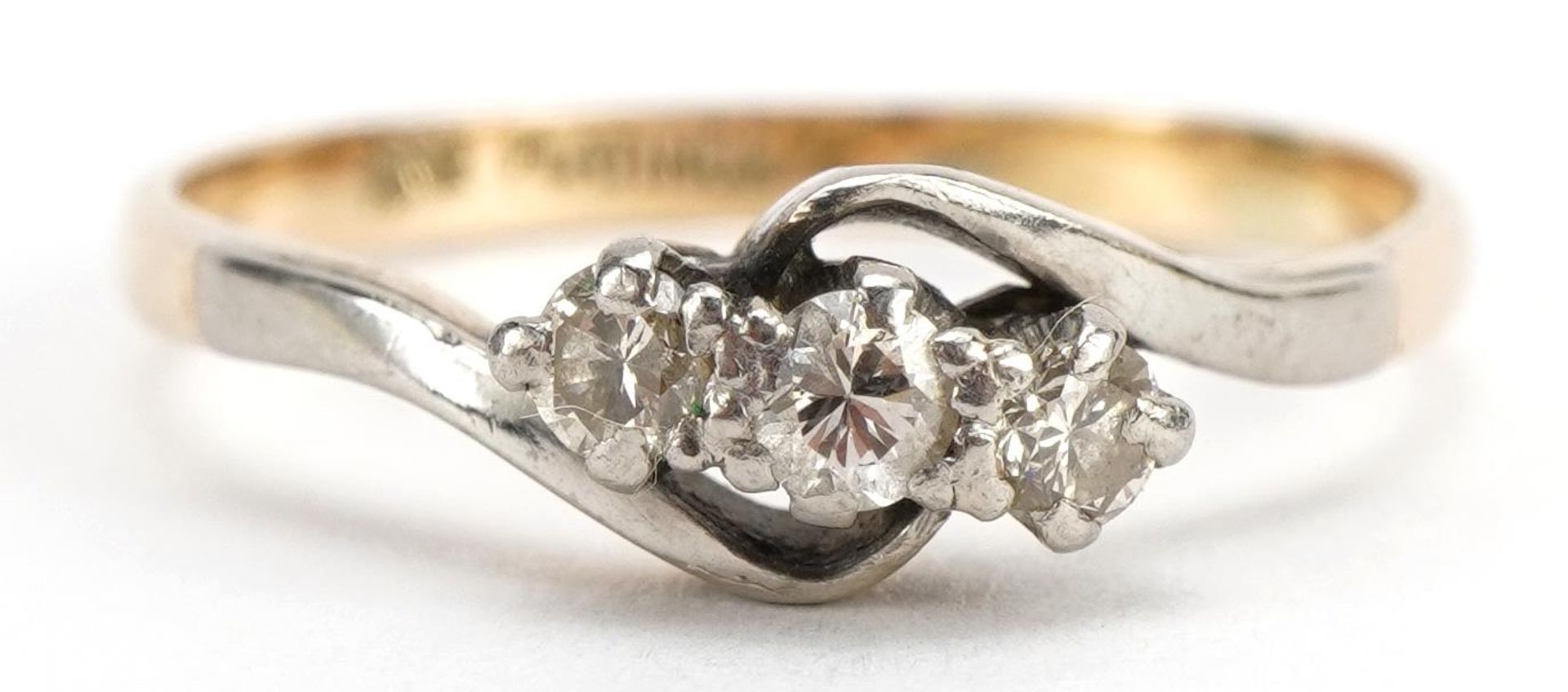 18ct gold and platinum diamond three stone crossover ring, the central diamond approximately 2.5mm