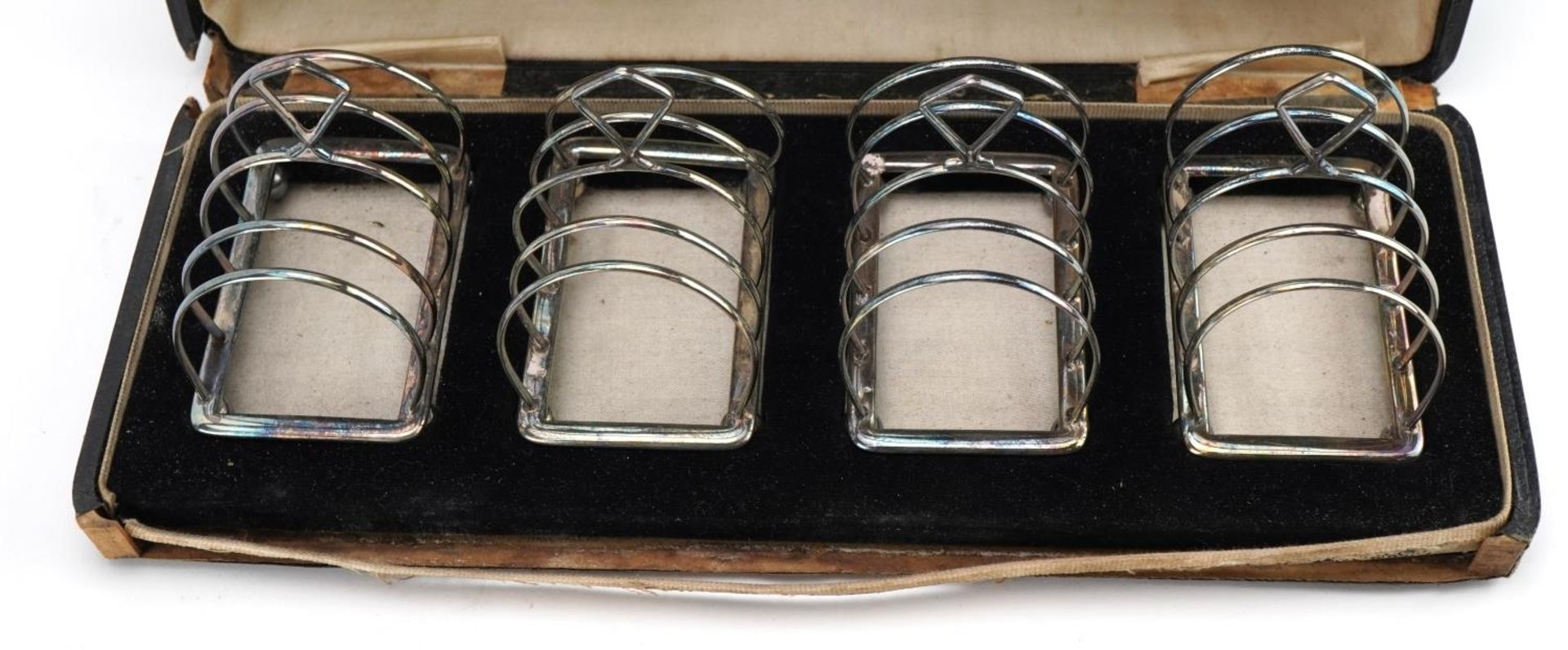 Adie Brothers Ltd, set of four George V silver four sliced toast racks with ball feet housed in a - Image 2 of 4