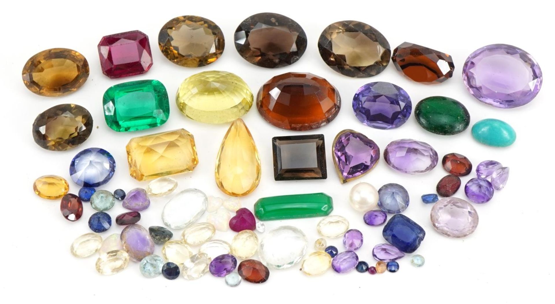 Collection of loose gemstones including amethyst, smoky quartz, citrine and opal love hearts, the