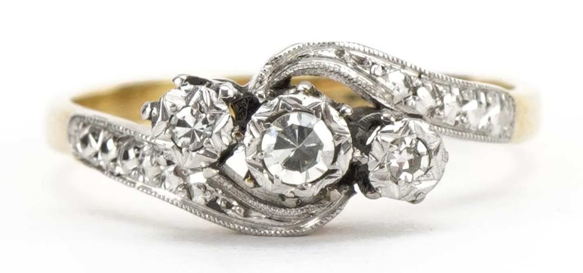 18ct gold and platinum diamond three stone crossover ring, the largest diamond approximately 2.4mm