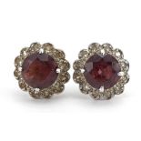 Pair of unmarked white gold garnet and diamond flower head stud earrings, 1.1cm high, 3.0g