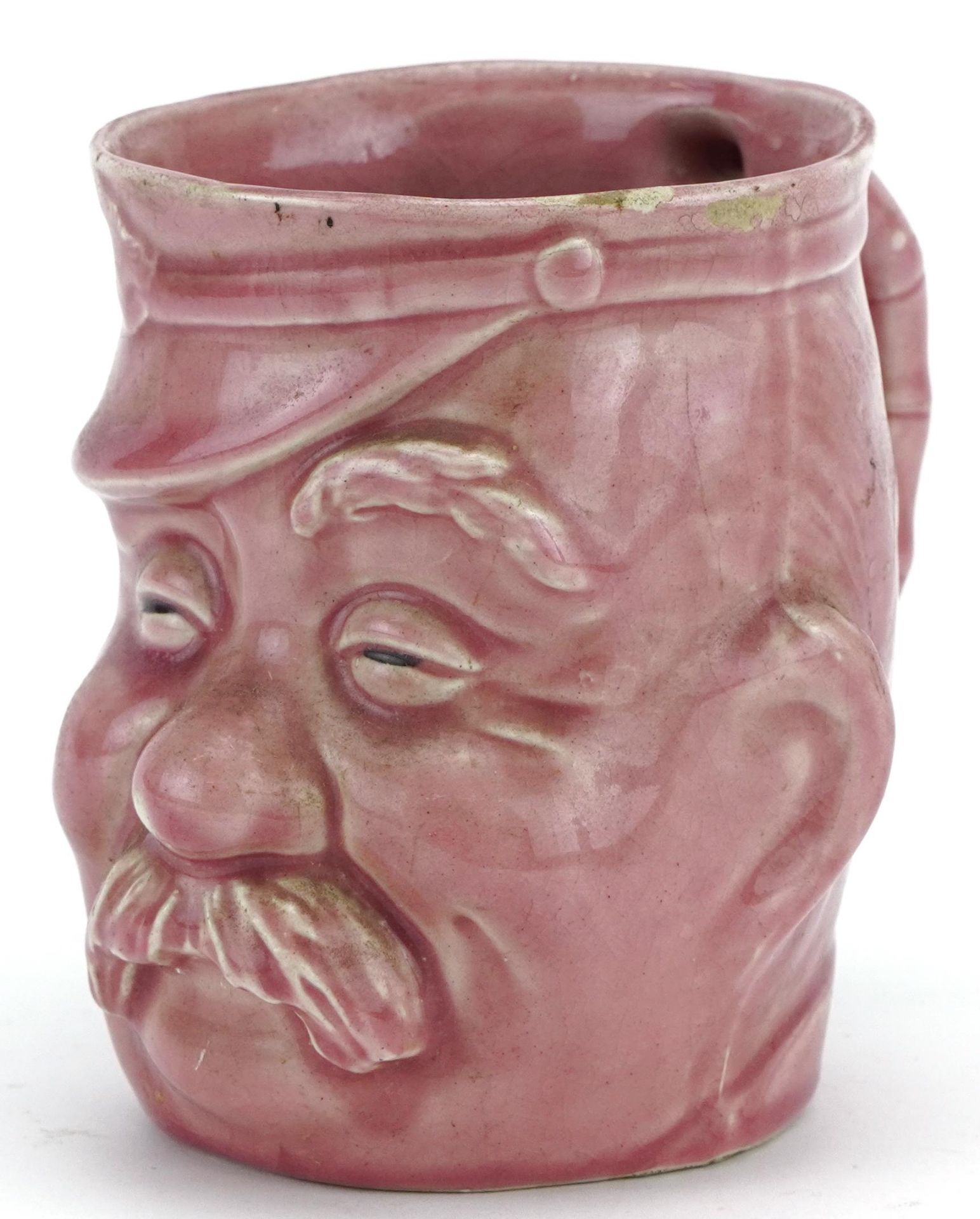 Military interest pink glazed mug in the form of a Bruce Bairnsfather's Old Bill, 11.5cm high