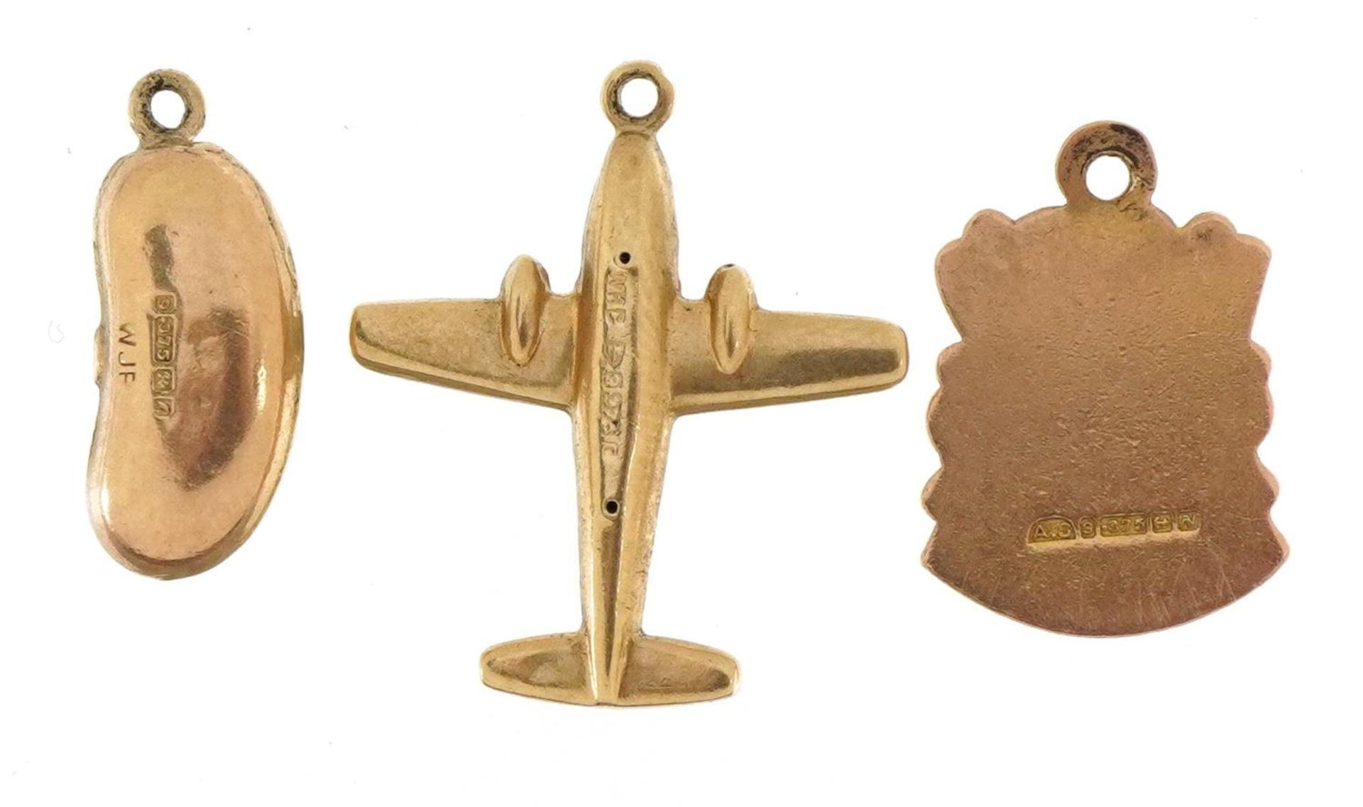 Three 9ct gold charms comprising aeroplane, bean and enamelled Sussex badge, the largest 2.0cm high, - Image 2 of 3