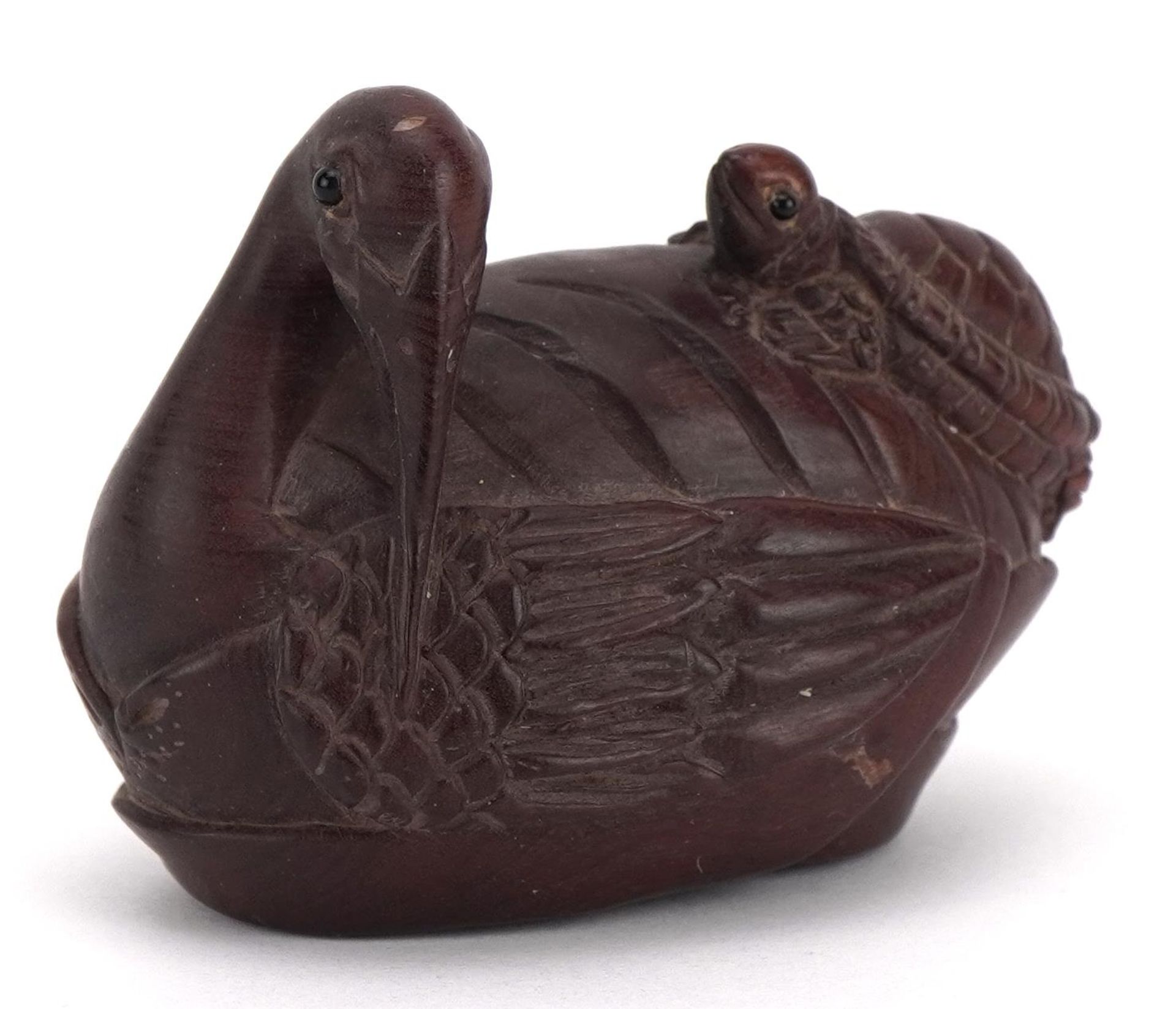 Japanese carved wood netsuke of a bird and tortoise, mother of pearl insert to the base, 5.5cm wide