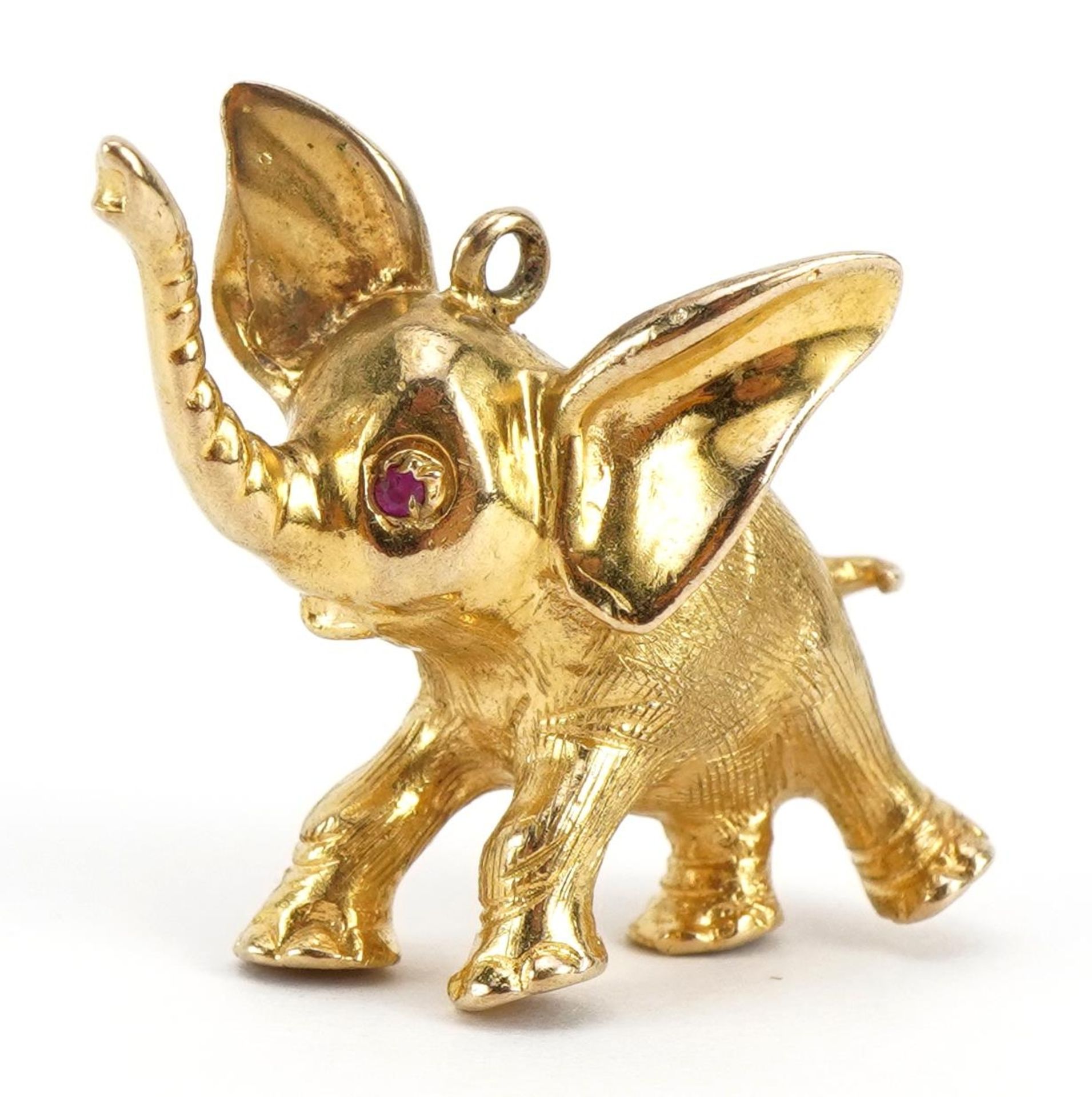 9ct gold elephant pendant with ruby set eye, 2.5cm high, 7.6g