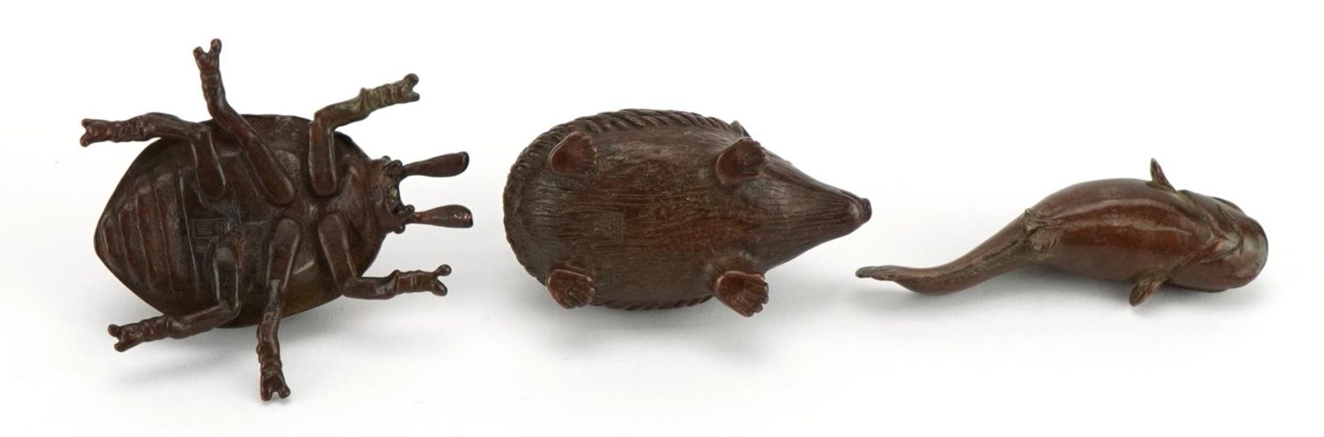 Three Japanese patinated bronze animals comprising hedgehog, beetle and fish, each with impressed - Image 3 of 4