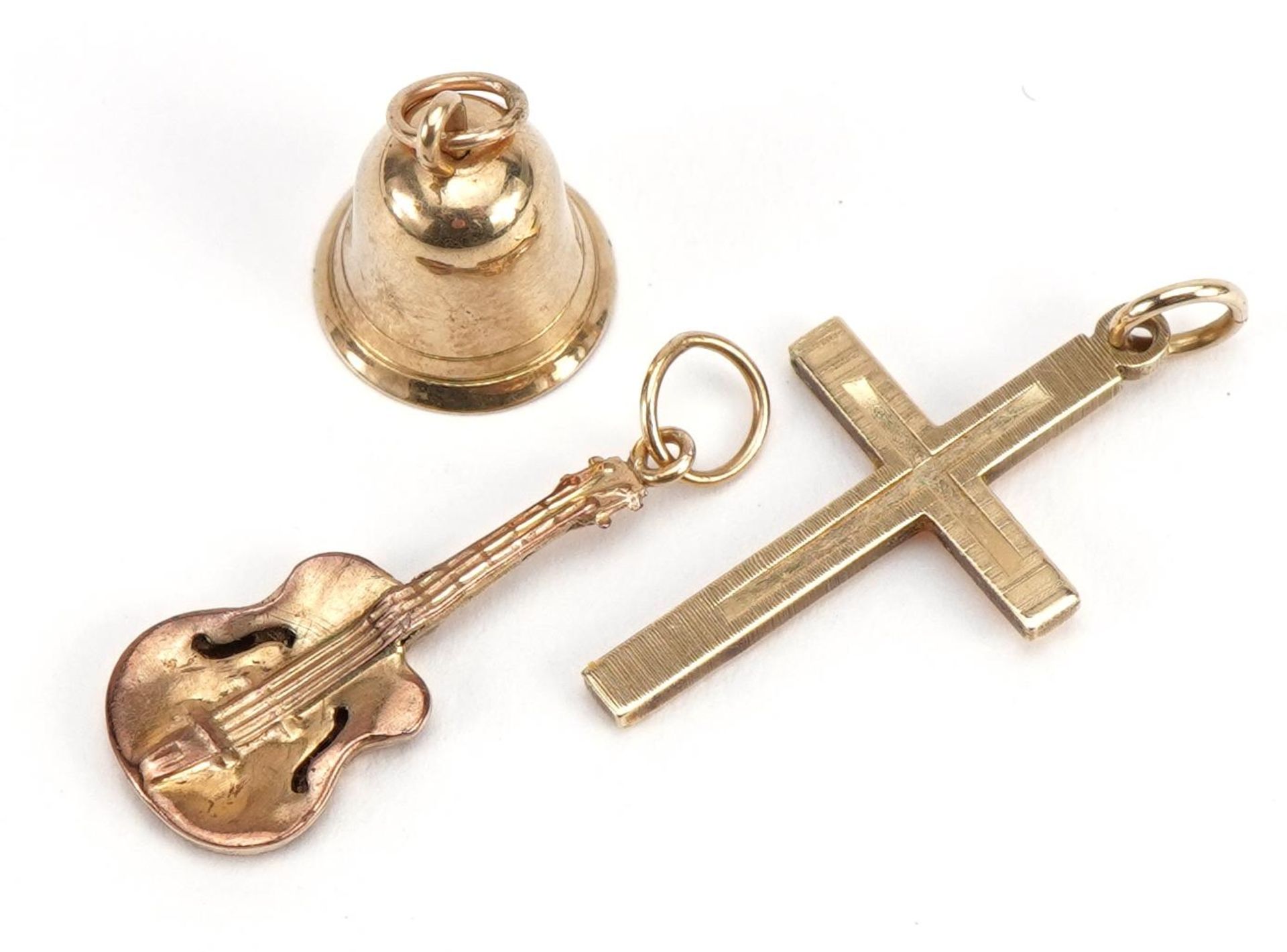 Three 9ct gold charms comprising cross, bell and guitar, the largest 2.3cm high, total 2.1g - Bild 3 aus 5