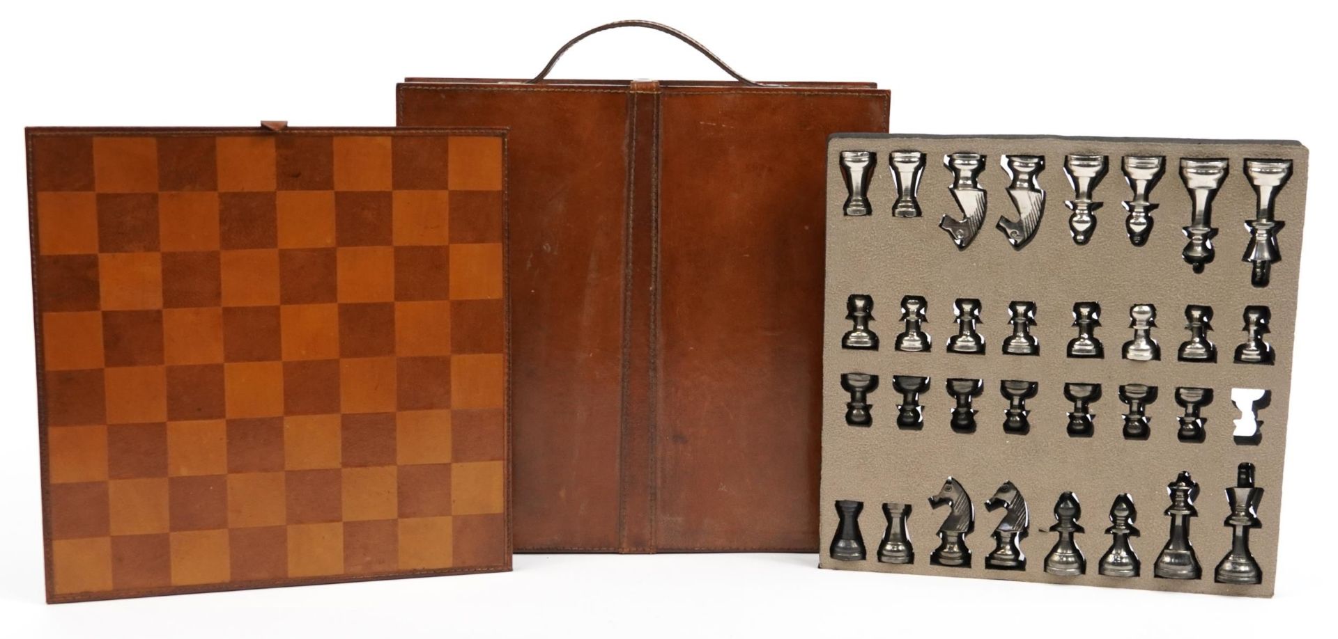 Tan leather cased travelling chess set with cast metal pieces, the largest piece 8cm high
