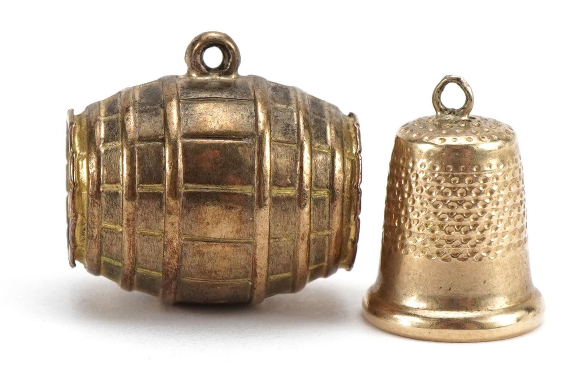 Two 9ct gold charms comprising barrel and thimble, the largest 1.7cm high, 2.9g