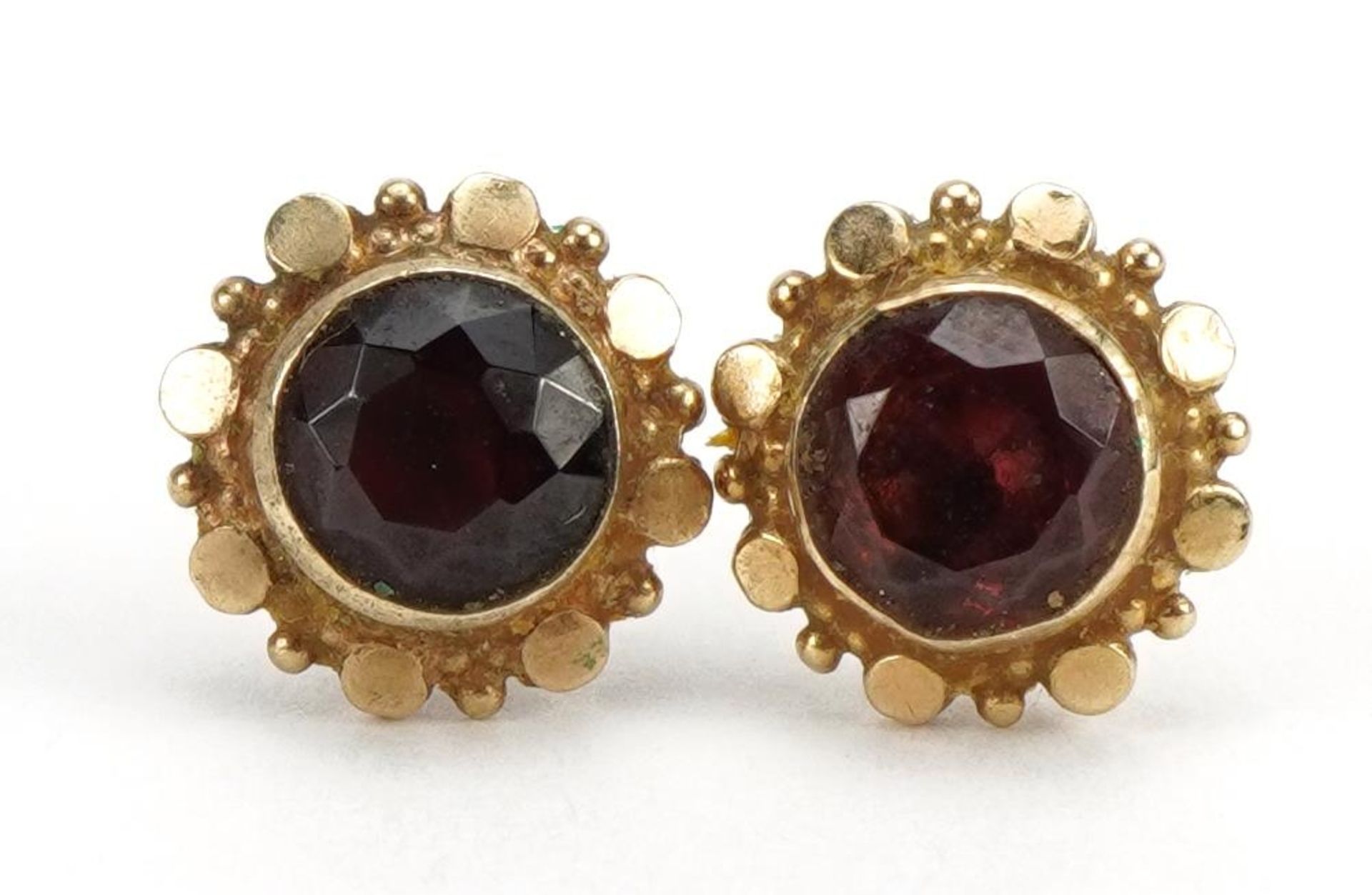 Pair of unmarked gold garnet stud earrings, 1.0cm high, 1.7g