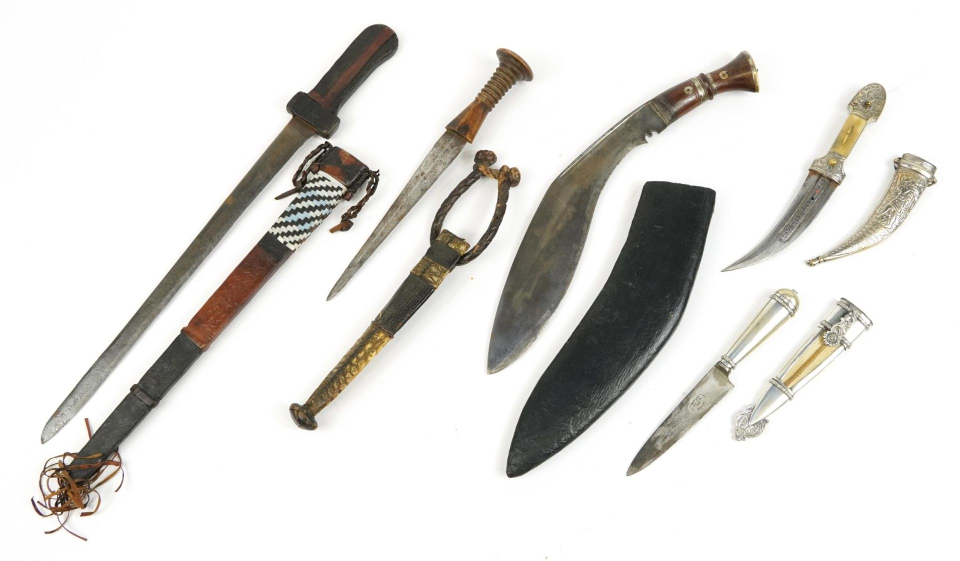Five Middle Eastern knives and daggers with sheaths including one with crocodile skin sheath, one