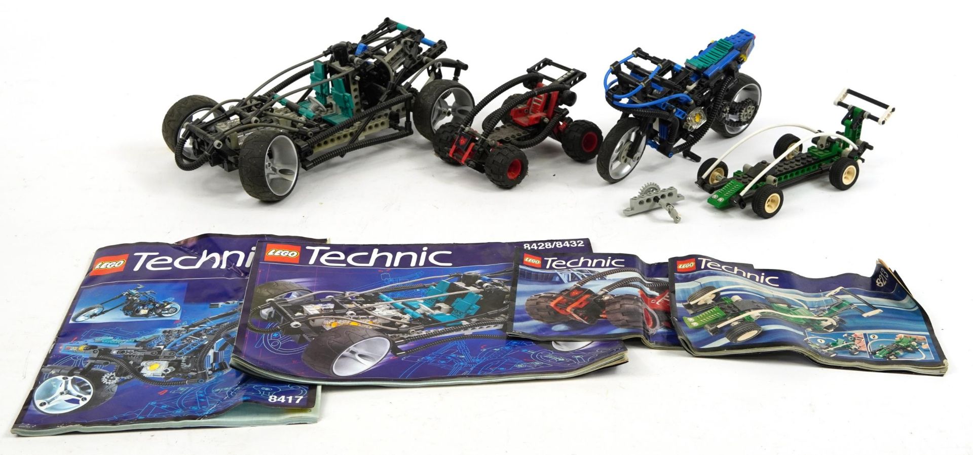 Three vintage Lego Technic racing cars and motor bike with instructions comprising numbers 8417,