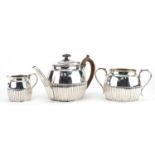 Lambert & Co, Victorian silver three piece tea service with demi fluted body, the teapot with wooden
