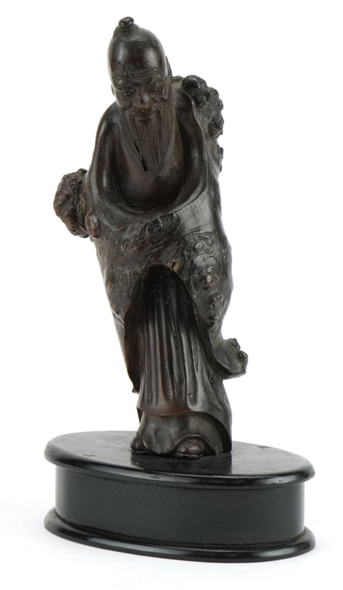 Chinese root wood carving of an elder raised on a later oval ebonised base, overall 23.5cm high