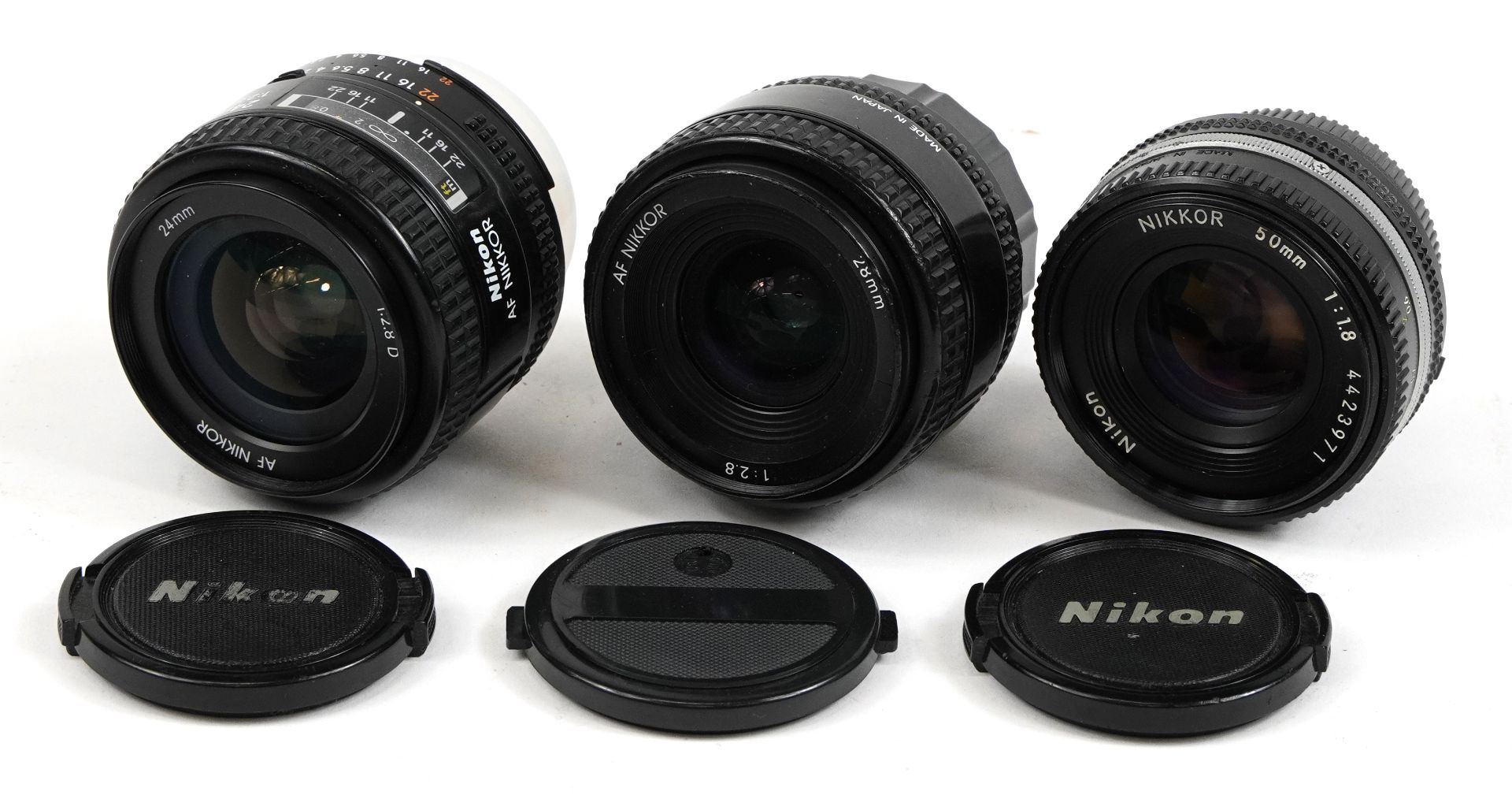 Three Nikon camera lenses comprising 50mm, 28mm and 24mm