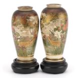 Pair of Japanese Satsuma pottery vases raised on hardwood stands, each hand painted with wisteria, Y