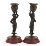 Pair of 19th century French patinated bronze Blackamoor candlesticks raised on circular rouge marble