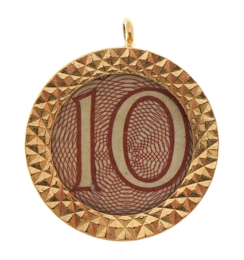 9ct gold emergency ten shilling note charm, 1.9cm in diameter, 3.3g