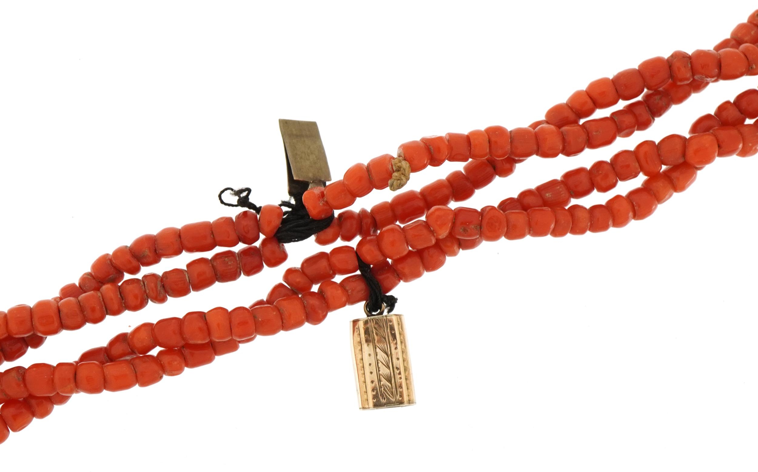 Coral four strand bead necklace with unmarked gold engraved clasp, possibly Victorian, 38cm in