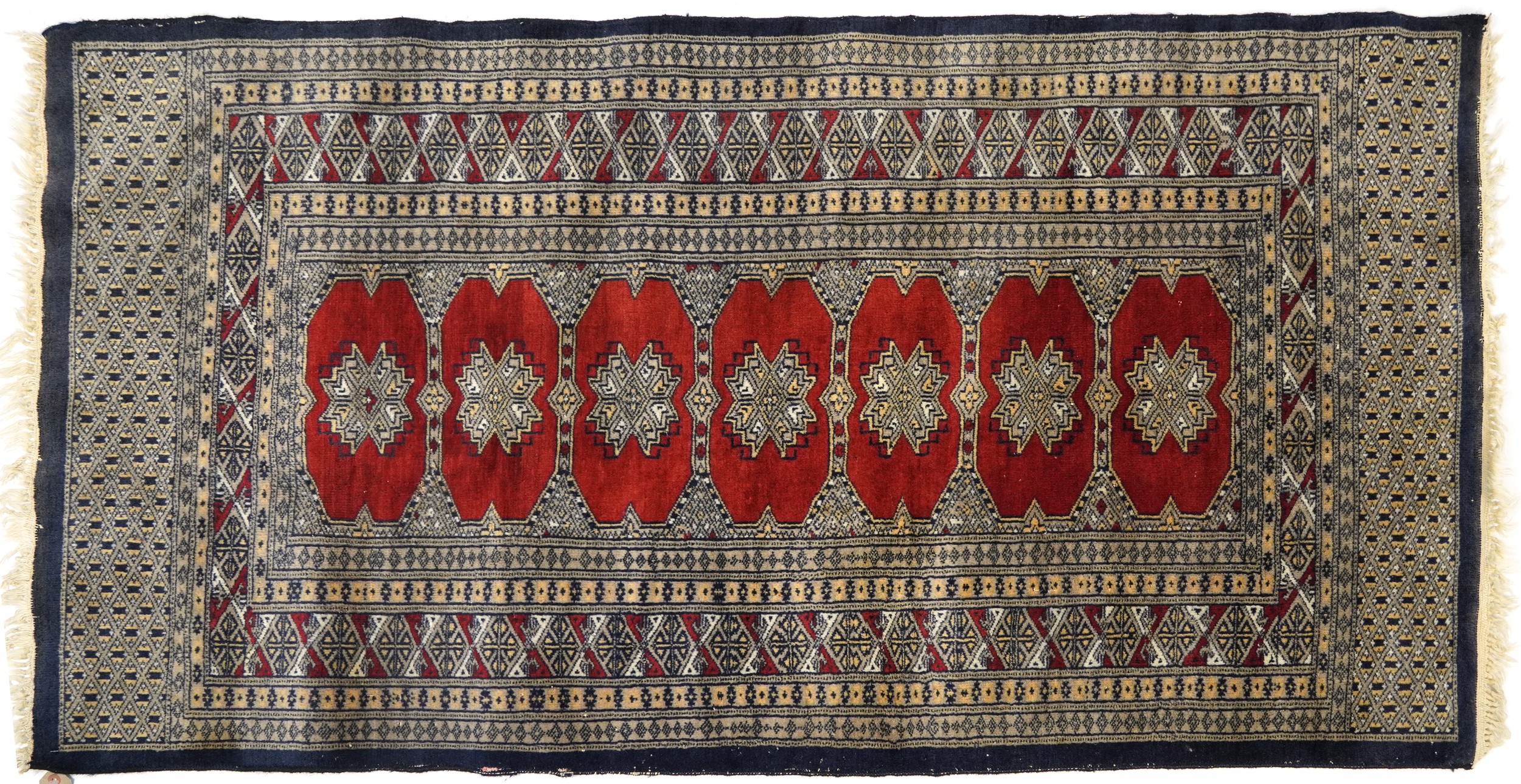 Rectangular red and blue ground rug with all over geometric design, 165cm x 92cm