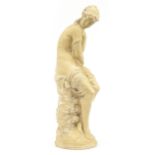 Large plaster figurine of a semi nude maiden seated on a rock, 65cm high