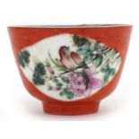 Chinese porcelain iron red ground tea bowl hand painted in the famille rose palette with birds