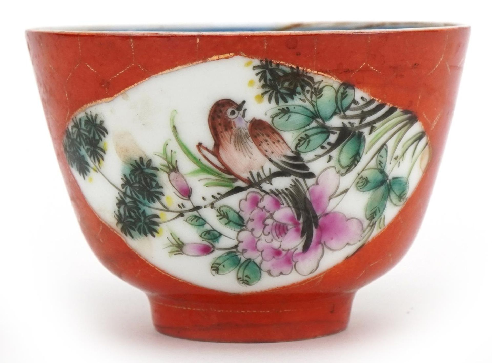 Chinese porcelain iron red ground tea bowl hand painted in the famille rose palette with birds