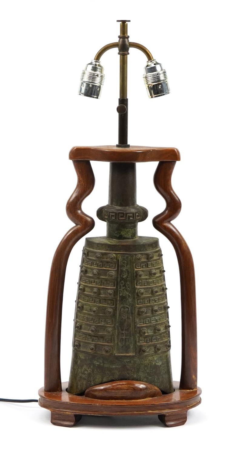 Chinese archaic style patinated metal bell design twin table lamp with hardwood mounts, 39.5cm high