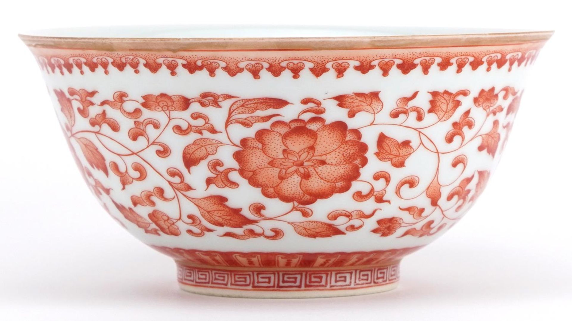 Chinese iron red porcelain bowl hand painted with flower heads amongst scrolling foliage, six figure