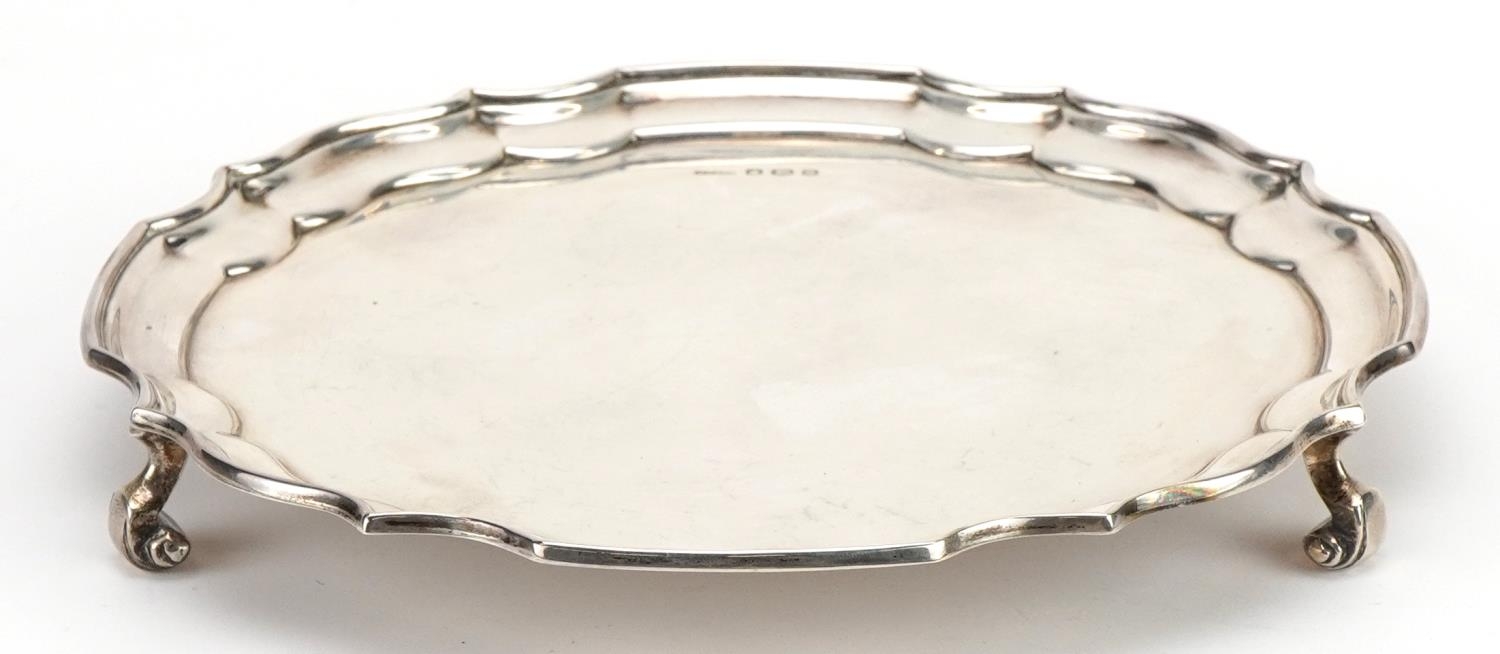 Harrison Fisher & Co, Elizabeth II circular silver salver raised on three scrolled feet, Sheffield