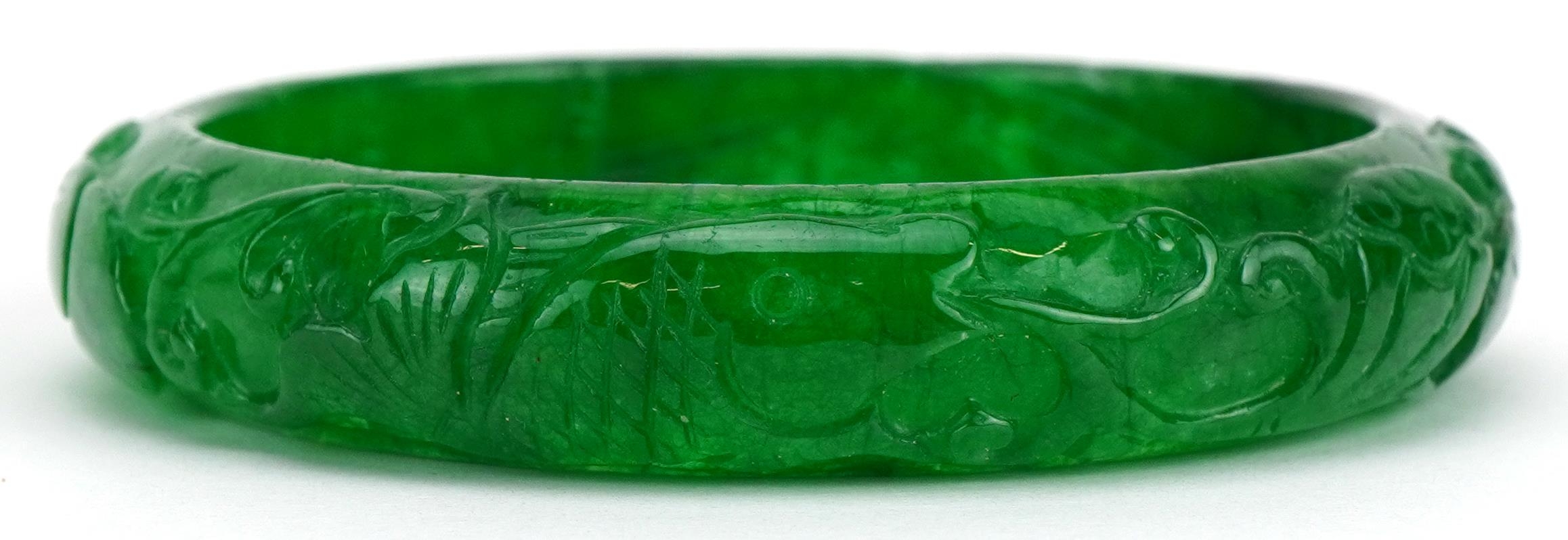 Chinese green jade bangle carved with foliage, 7cm in diameter, 46.8g