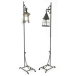 Pair of Arts and Crafts style black painted wrought iron floor standing lamps, 167cm high