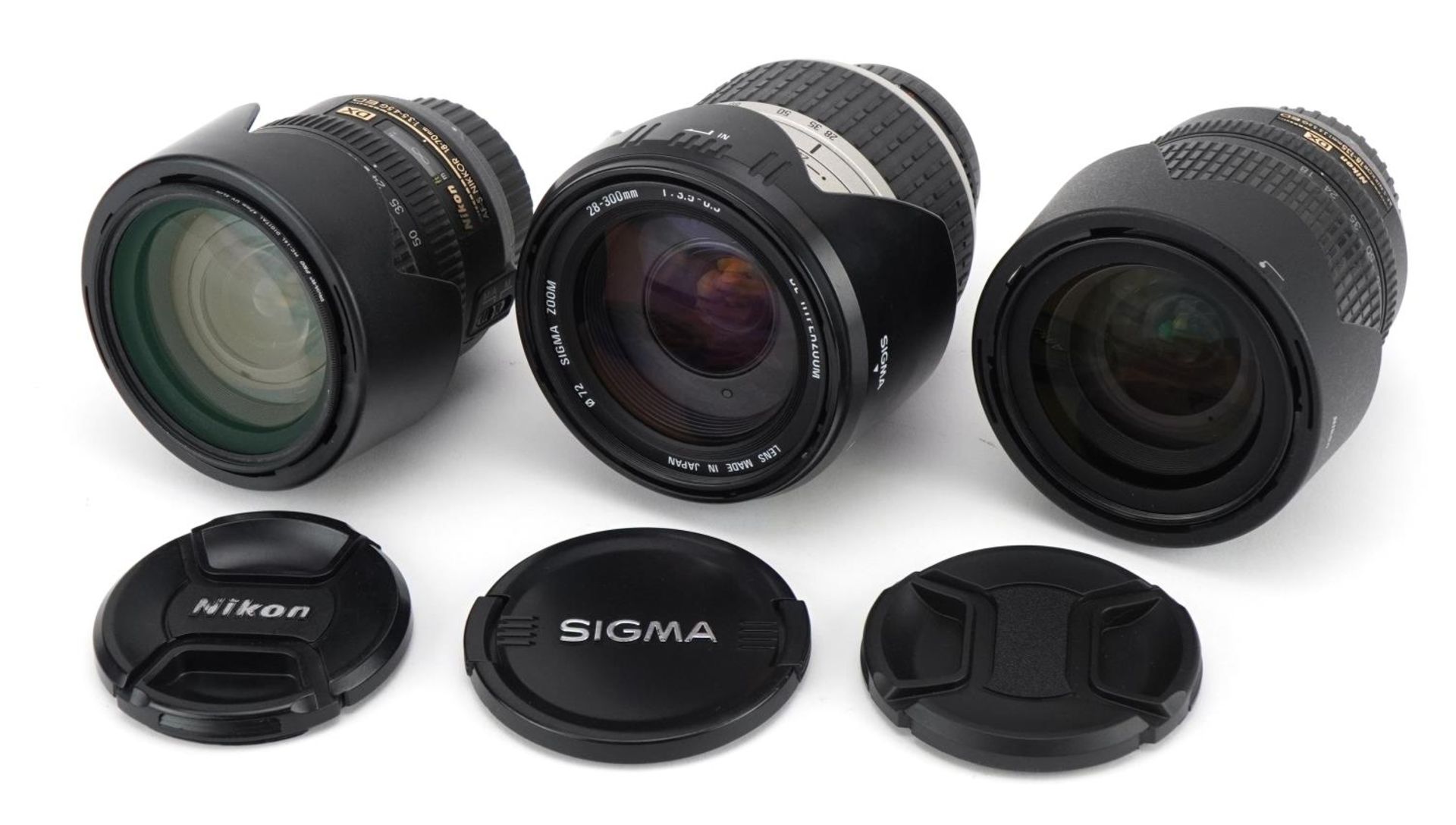 Three camera lenses comprising Sigma 28-300mm, Nikon 18-70mm and Nikon 18-135mm