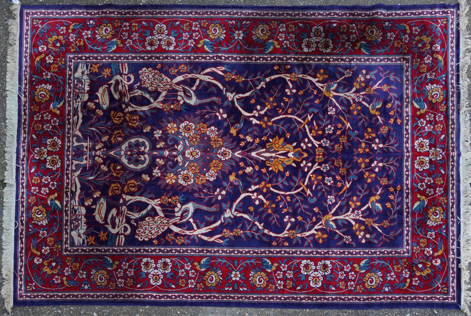 Rectangular Sarook Kashan silk rug decorated with birds amongst flowers onto a predominantly red and