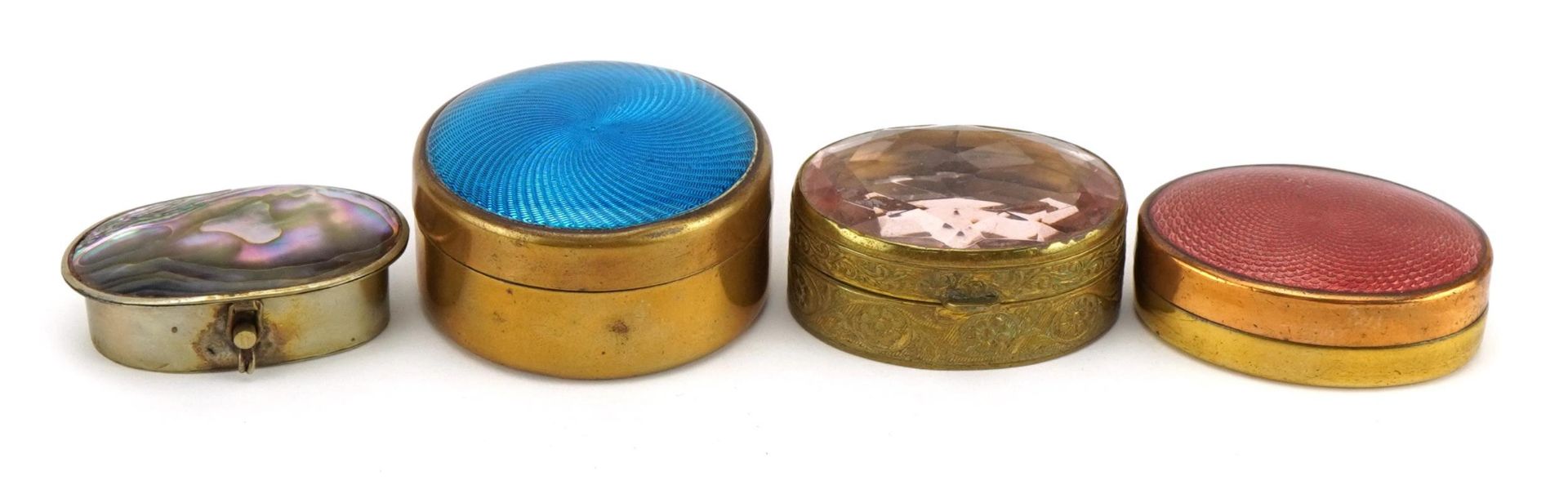 Three brass pillboxes and a Mexican white metal example with abalone lid, the largest 4.2cm in