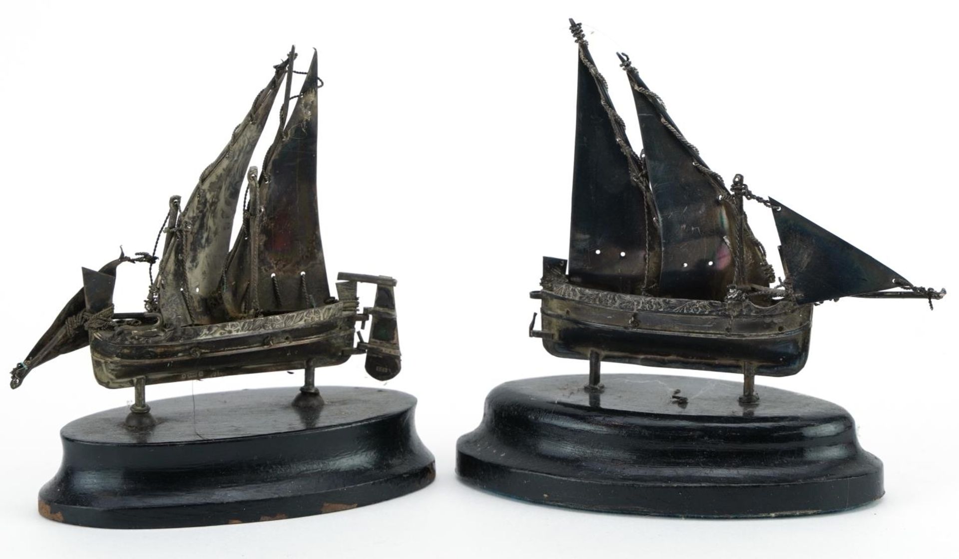 Two Maltese miniature silver sailing boats raised on ebony bases, the largest 10cm high For